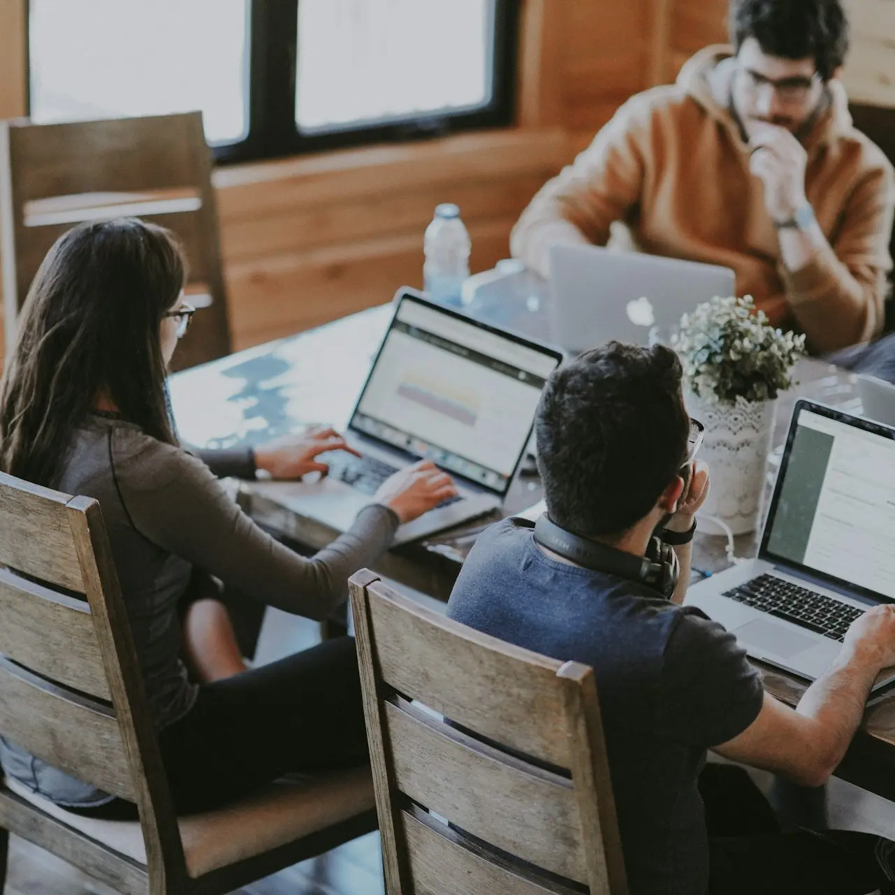 selective focus photography of woman and man using MacBook Pro on table